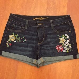 Dark blue denim shorts with embroidered flowers.